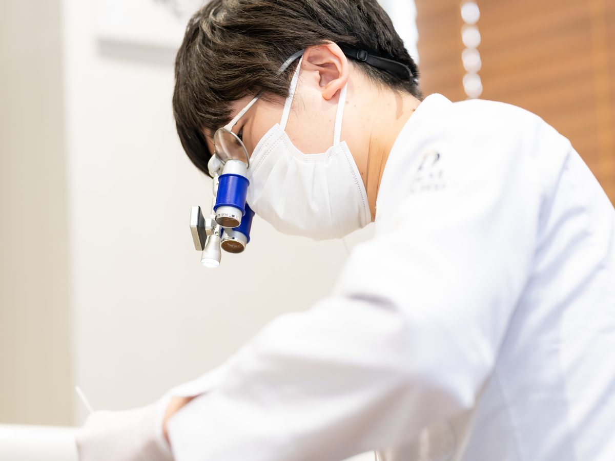 ルーペ(拡大鏡)を使って治療する歯科医師