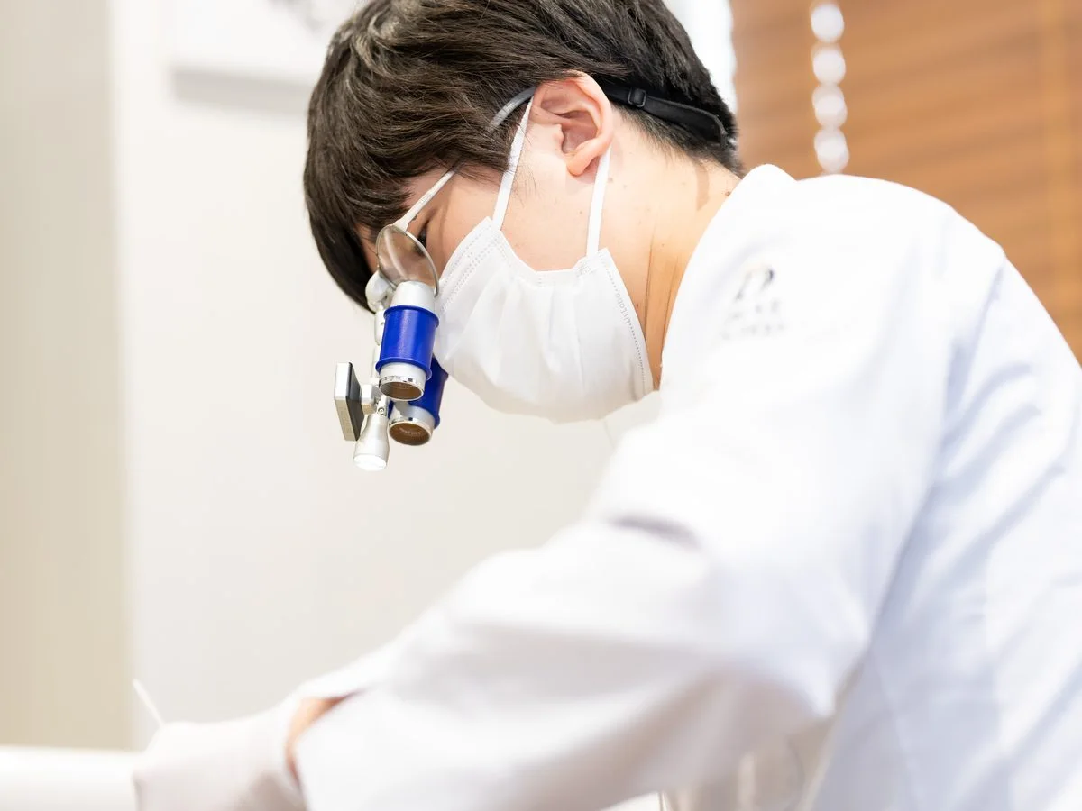 ルーペ（拡大鏡）を使って治療する歯科医師